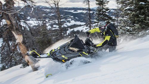 Yellow and Black Polaris Snowmobile riding through the snow